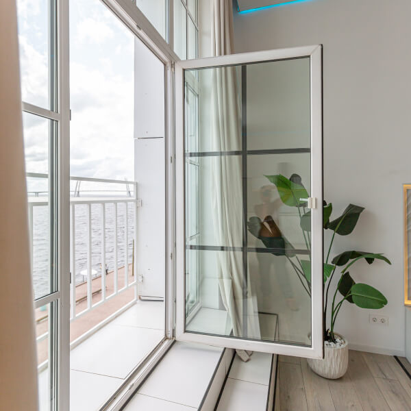 Fenêtre ouverte avec vitrage isolant donnant sur un balcon, illustrant le lien entre prix des fenêtres et efficacité énergétique au Québec